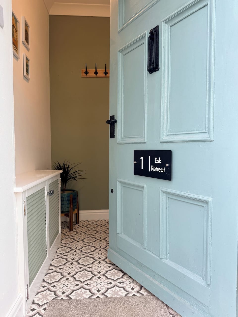 Charming entryway with patterned tile and a welcoming blue front door