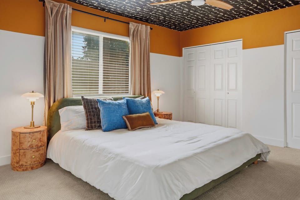 Spacious king bedroom with TV, ceiling fan, full-length mirror, and spacious closets. 