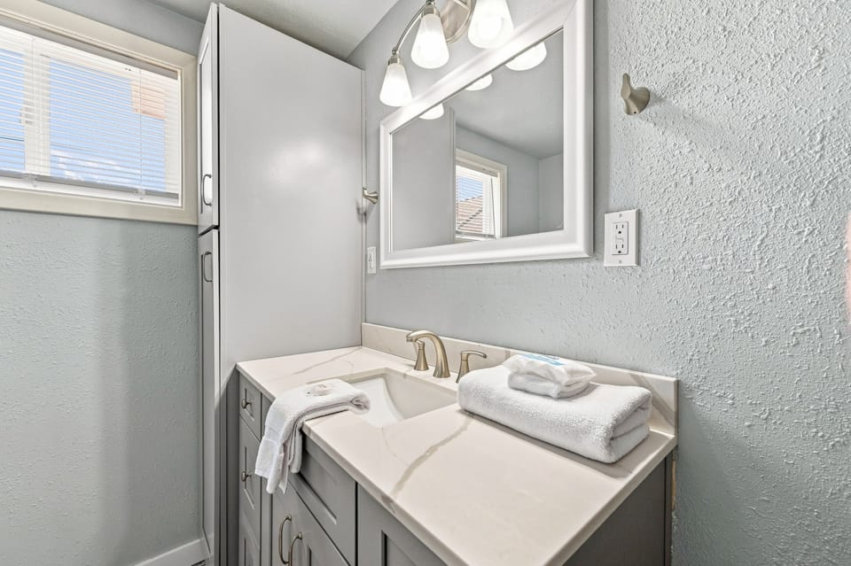 Refresh in your bright, modern bathroom with fresh towels, soft lighting, and a spacious vanity—a serene space designed just for you.