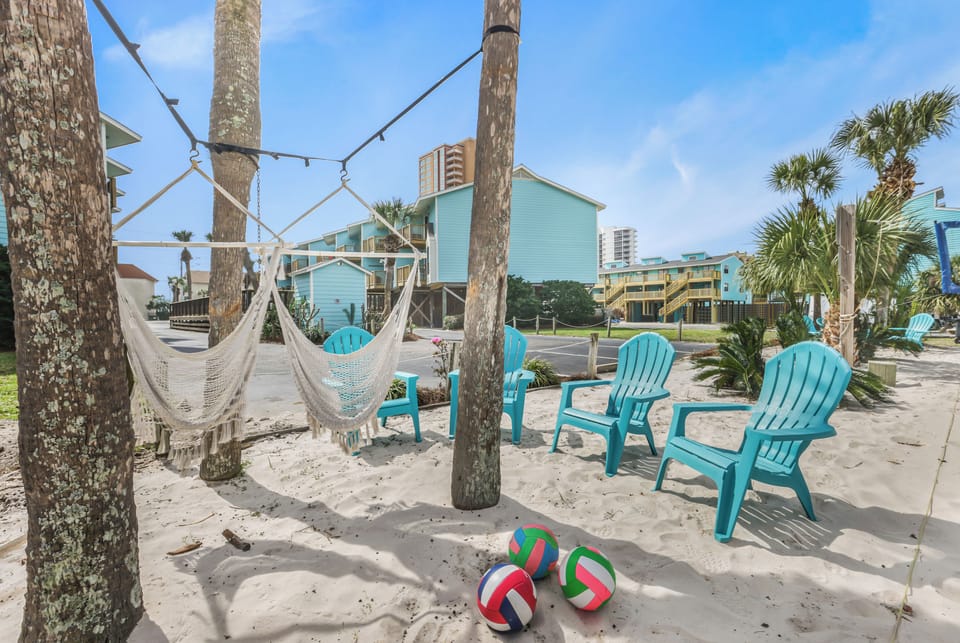 Tropical sandy lounge with hammocks, Adirondack chairs, and resort vibes