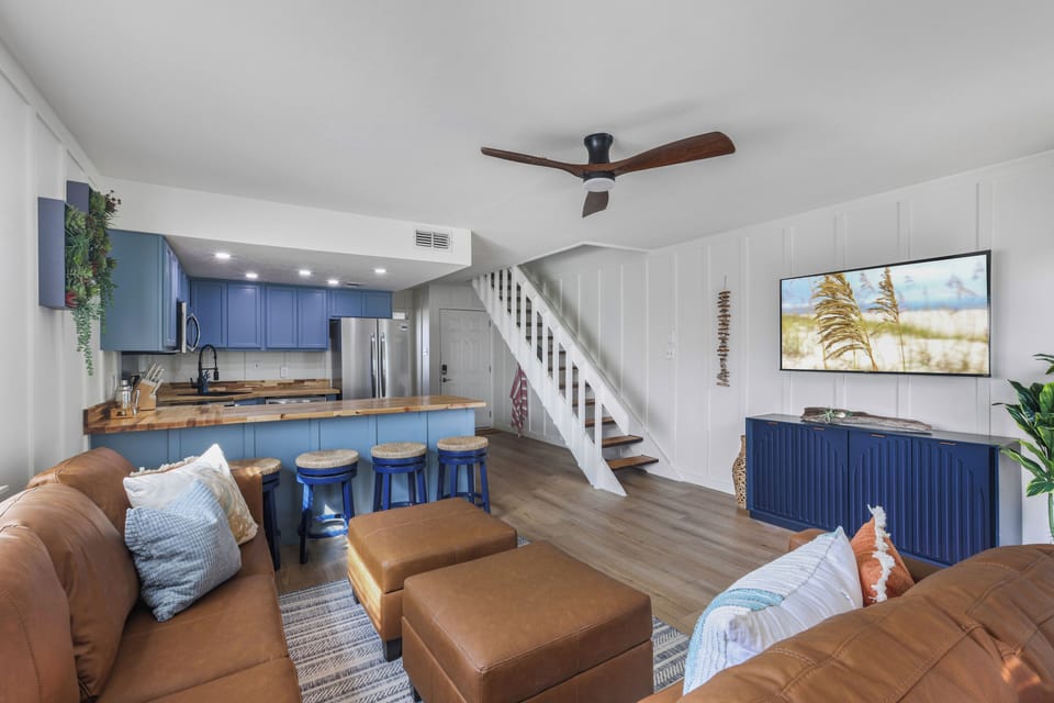 Bright coastal living room with breakfast bar, stylish kitchen, and seating for 5