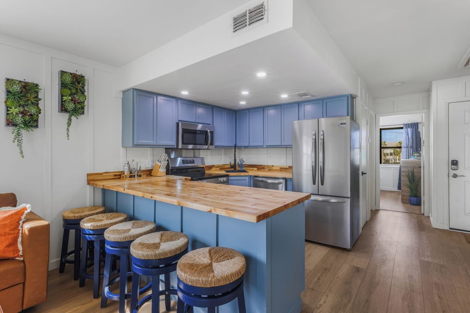 Bright modern kitchen with large island, bar seating, and stainless appliances