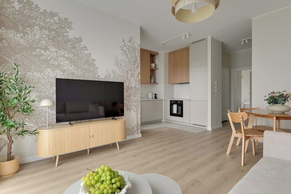 Salon stanowi komfortową przestrzeń do wypoczynku i wspólnego spędzania czasu. Znajduje się w nim wygodna rozkładana sofa, telewizor Smart TV z dostępem do kanałów kablowych oraz część jadalniana ze stołem i krzesłami.