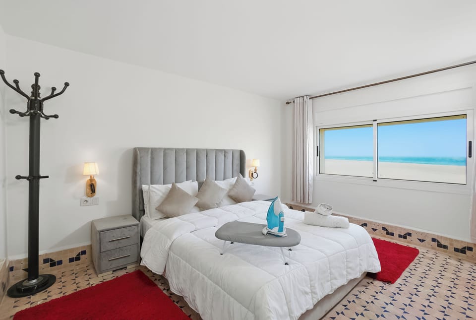 Bright coastal bedroom with ocean views, plush bed, and serene natural light