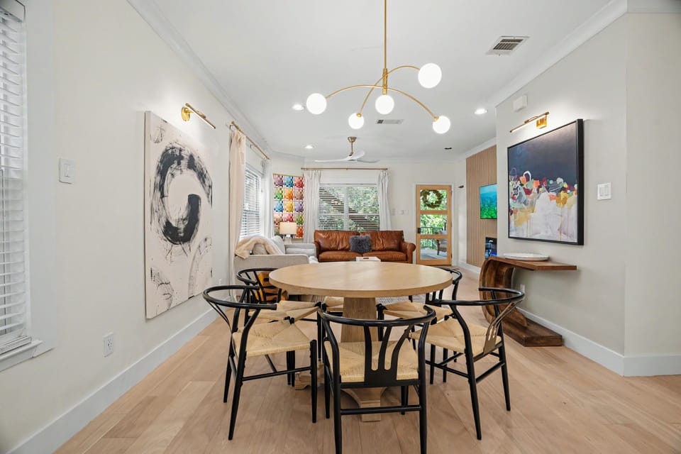 Bright modern dining and living space with designer lighting and art
