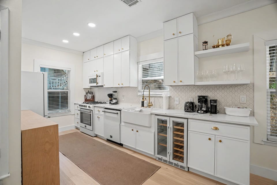 Bright modern kitchen with wine fridge, farmhouse sink, and coffee station