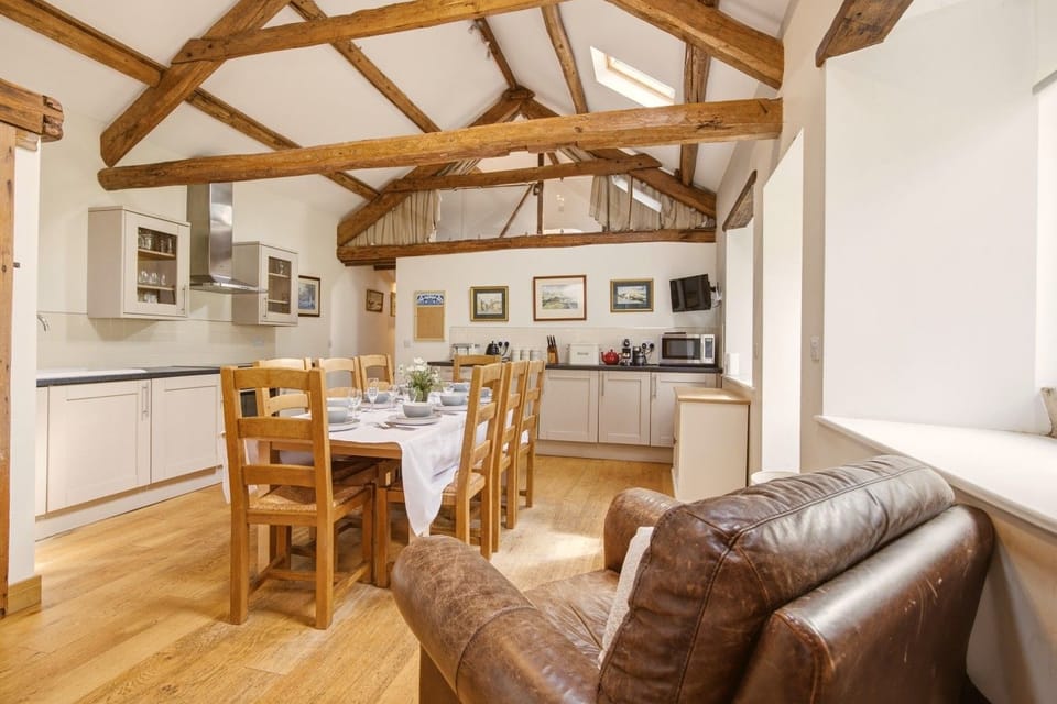 Hayloft kitchen and dining area beneath original exposed timber beams