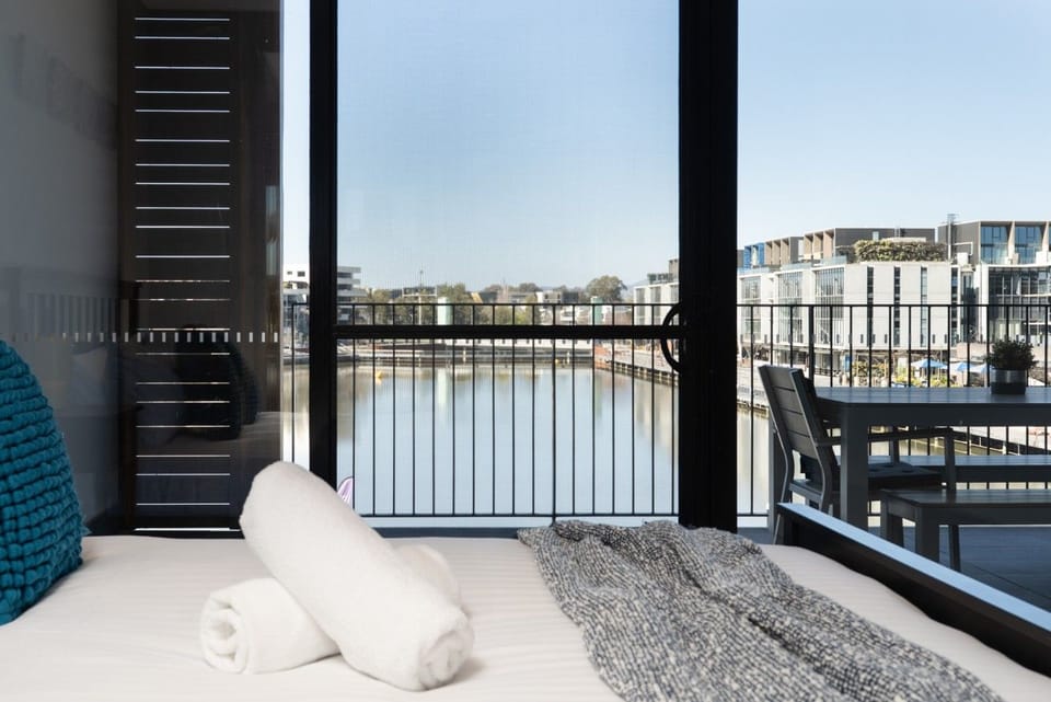 Wake up to beautiful waterfront views from this inviting bedroom, with direct access to the balcony for a refreshing start to the day.
