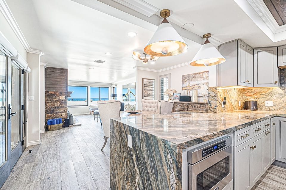 Spacious kitchen with a large island, ample counter space, and ocean views beyond.
                