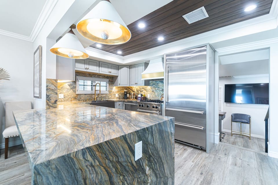 Large kitchen island offers generous counter space for preparing meals and serving snacks.
                