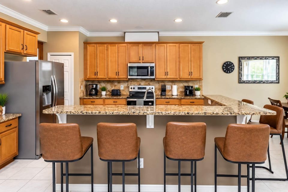 Gorgeous open-concept kitchen with stainless steel appliances and custom wood cabinetry.