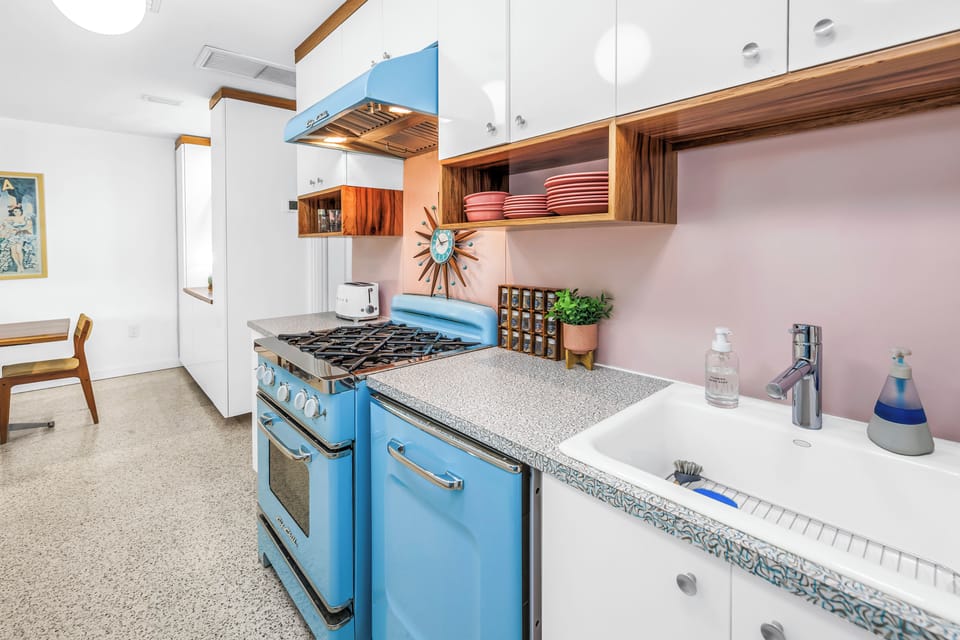 Retro-chic kitchen with farmhouse sink and eye-catching blue range
