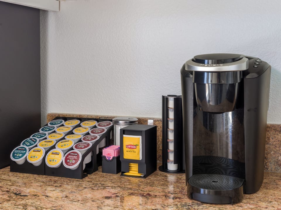 Keurig with included coffee pods, creamer, sugar, and Sweet'n Low