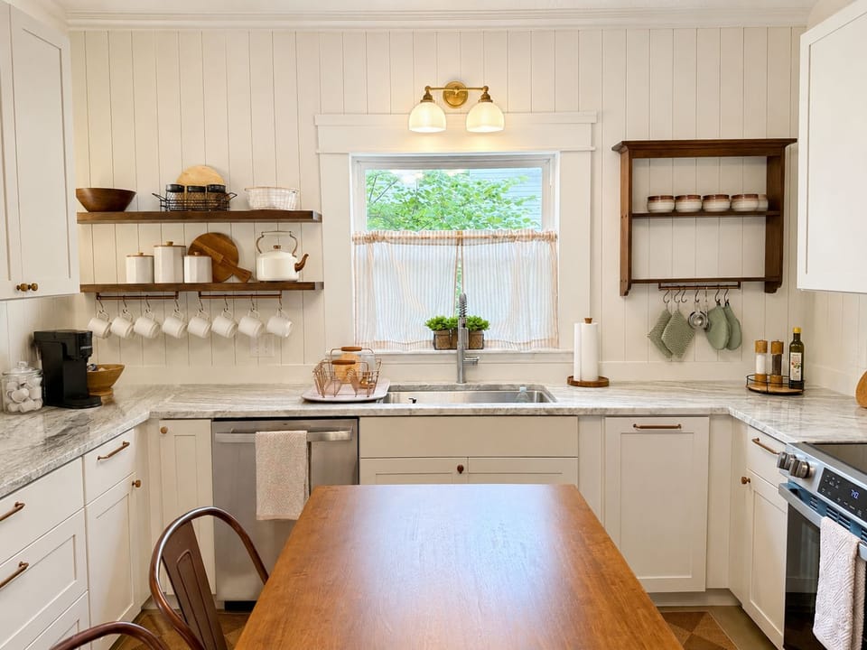 Bright farmhouse kitchen with wood island and charming open shelving