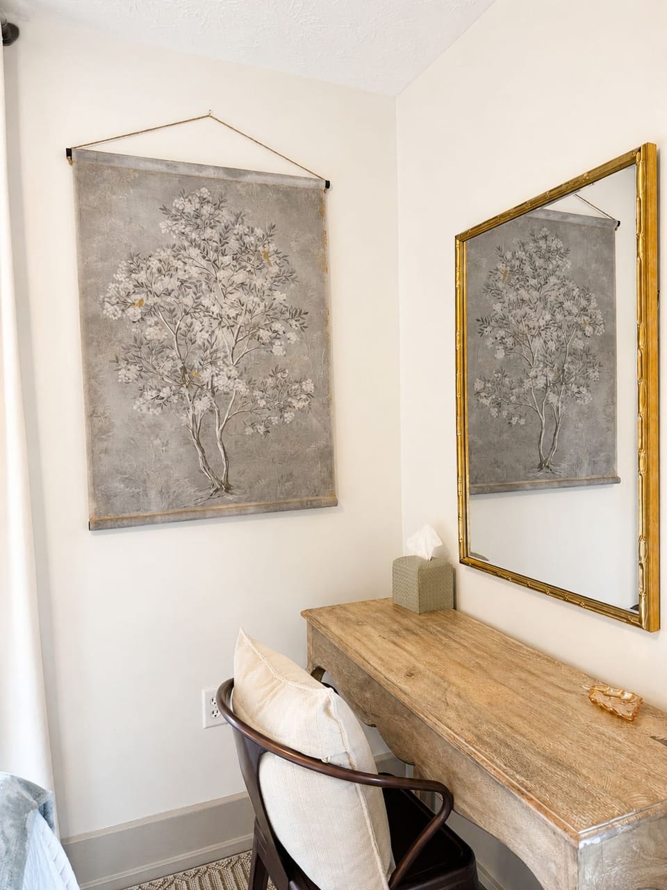 Bright, elegant vanity nook with rustic desk and oversized mirror