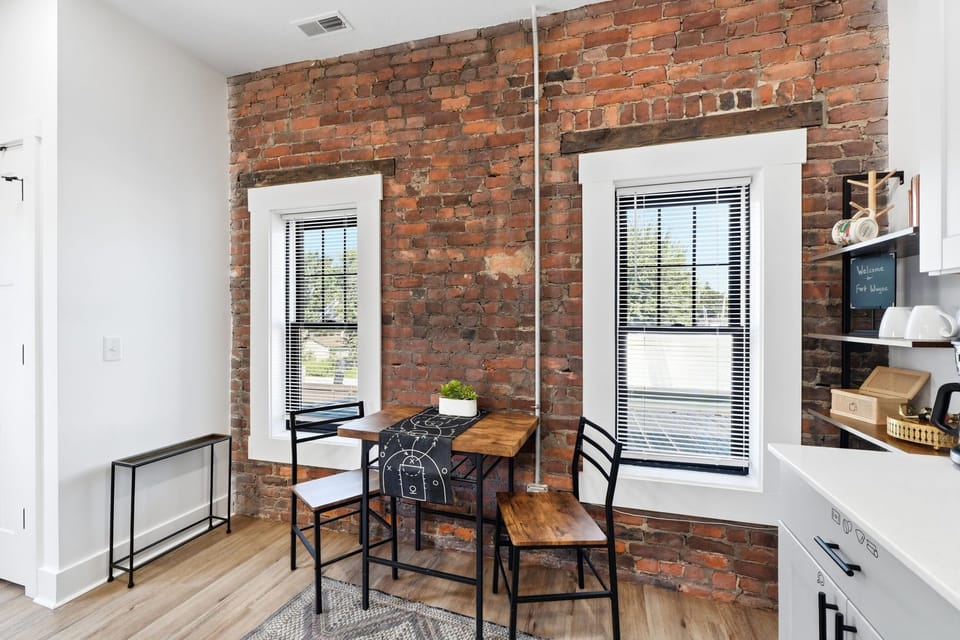 Enjoy cozy meals at the dedicated dining table set against exposed brick walls. A warm spot to plan your trip to nearby Promenade Park.