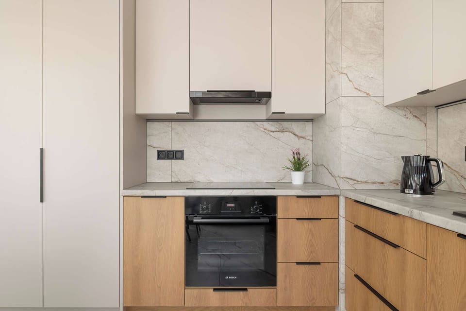 A bright and functional kitchen with wooden cabinets, a built in oven, and modern appliances. Its clean design provides a practical space for everyday cooking.