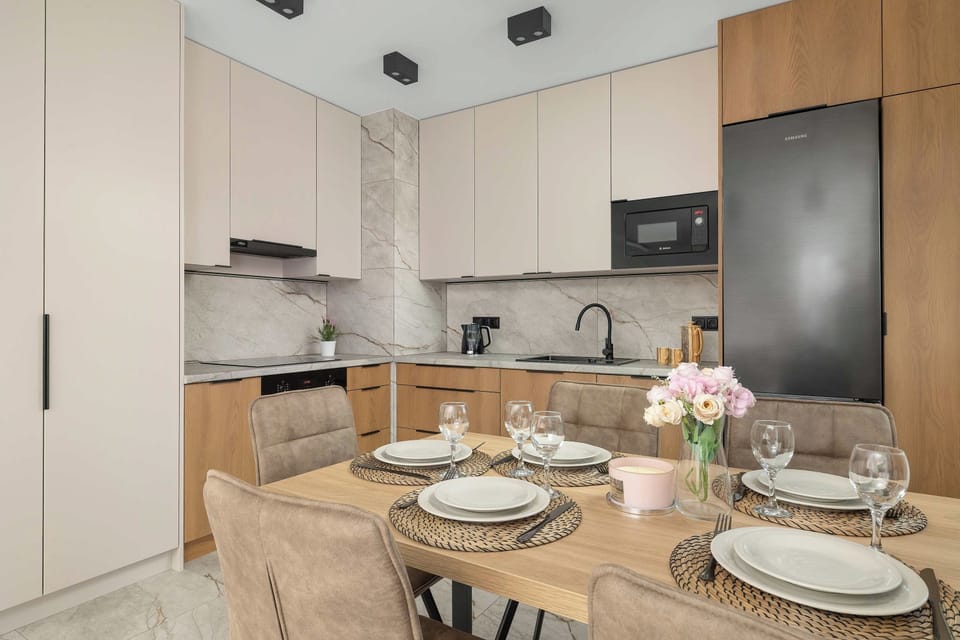A dining area set for a meal, located next to the modern kitchen. The bright space combines comfortable seating with a practical open plan layout.