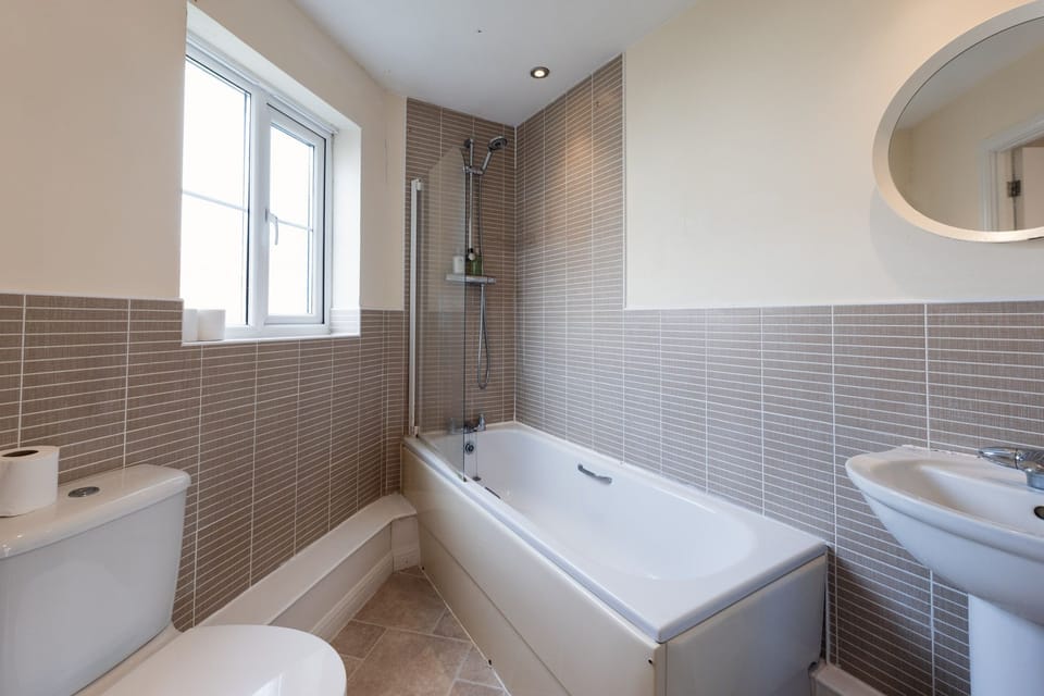 The family bathroom includes a toilet, sink, and a combined bath and shower