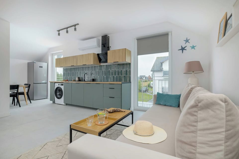 A spacious open-plan living area with a seating corner, a dining table, and a kitchen in the background.