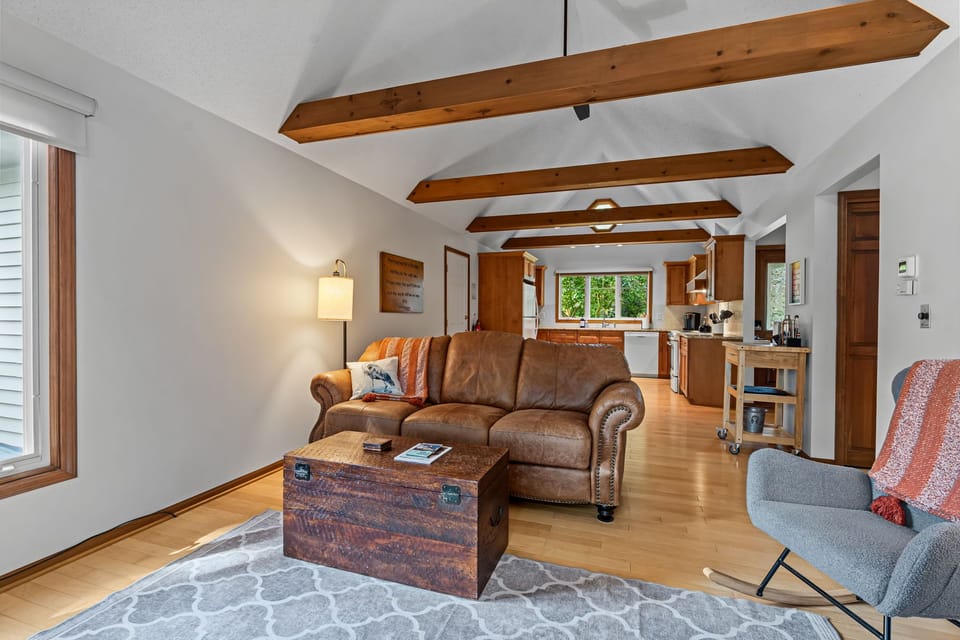Cozy vaulted living room with exposed beams and open kitchen