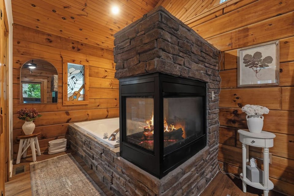 Cozy spa-style bath with soaking tub and stunning stone fireplace