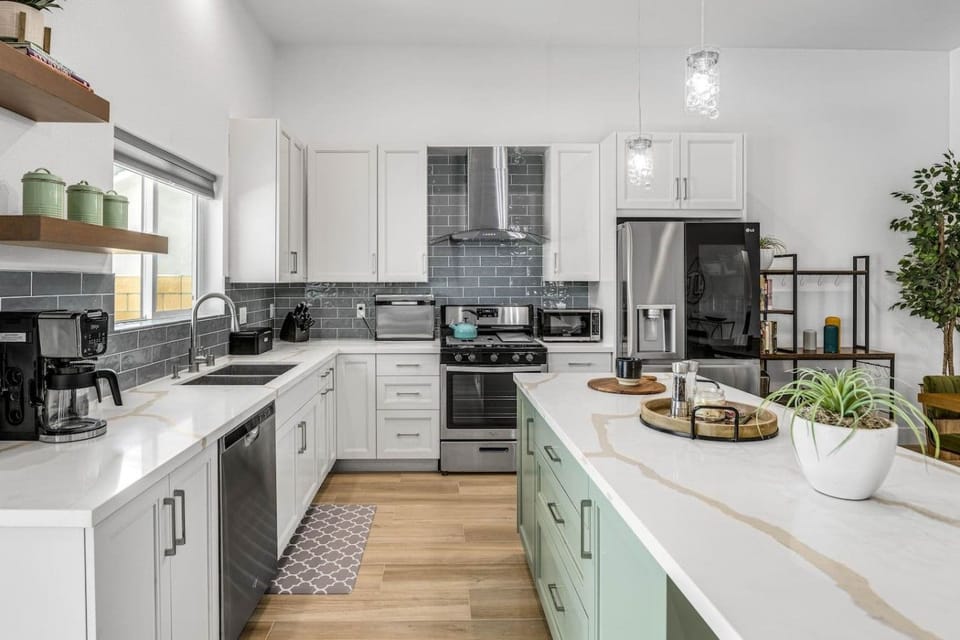 Everything you need - crisp white cabinetry, blue-gray subway tile, and quartz counters throughout