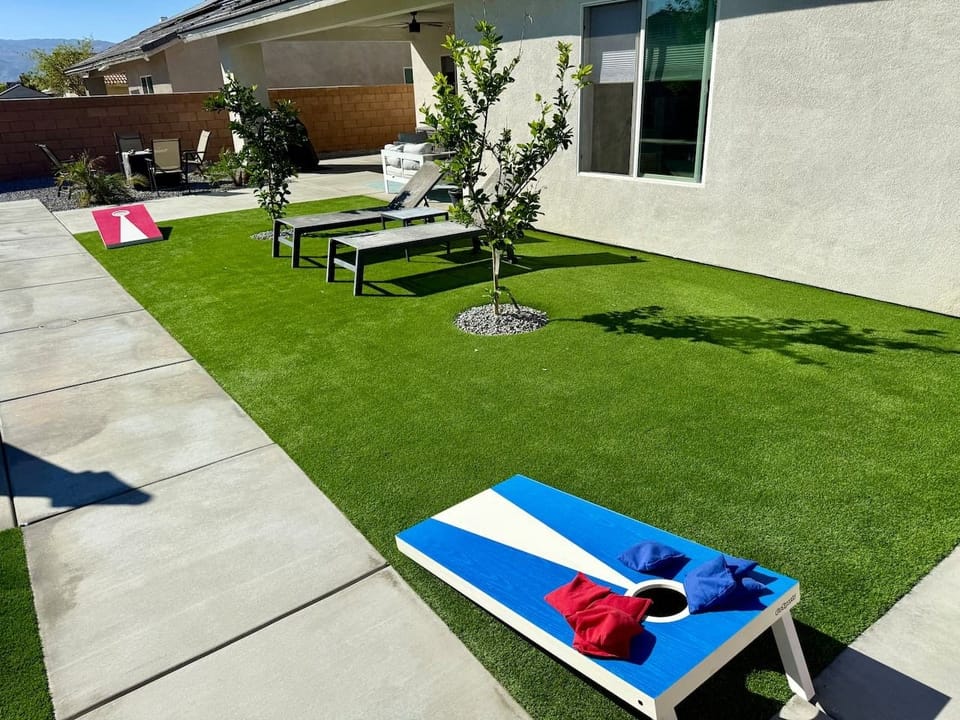 New turf and corn hole set - freshly landscaped yard ready for backyard games