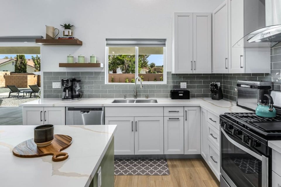 Everything you need - crisp white cabinetry, blue-gray subway tile, and quartz counters throughout