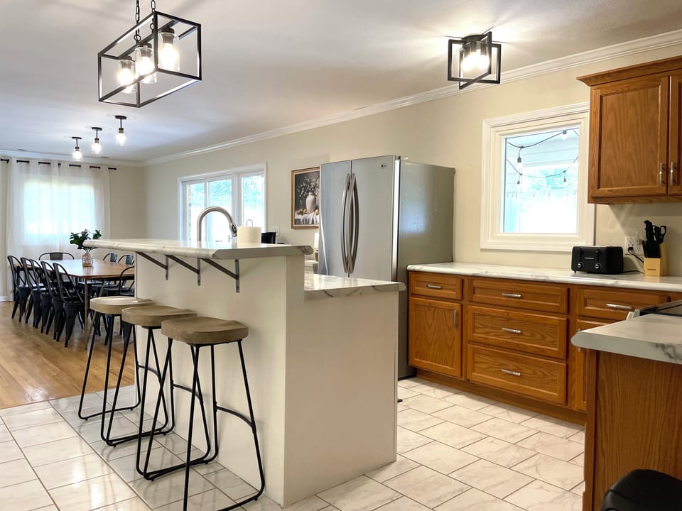 Cook and connect in the full kitchen, featuring generous counters, stainless appliances, and island seating for your helpers and taste-testers 👩‍🍳