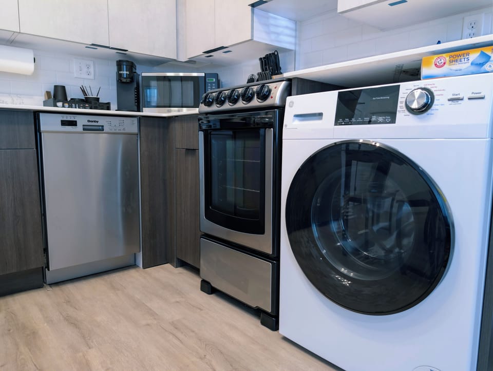 Modern kitchen with stainless appliances and convenient in-unit laundry