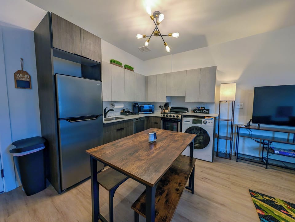 Modern kitchen with in-unit laundry, dining nook, and smart TV