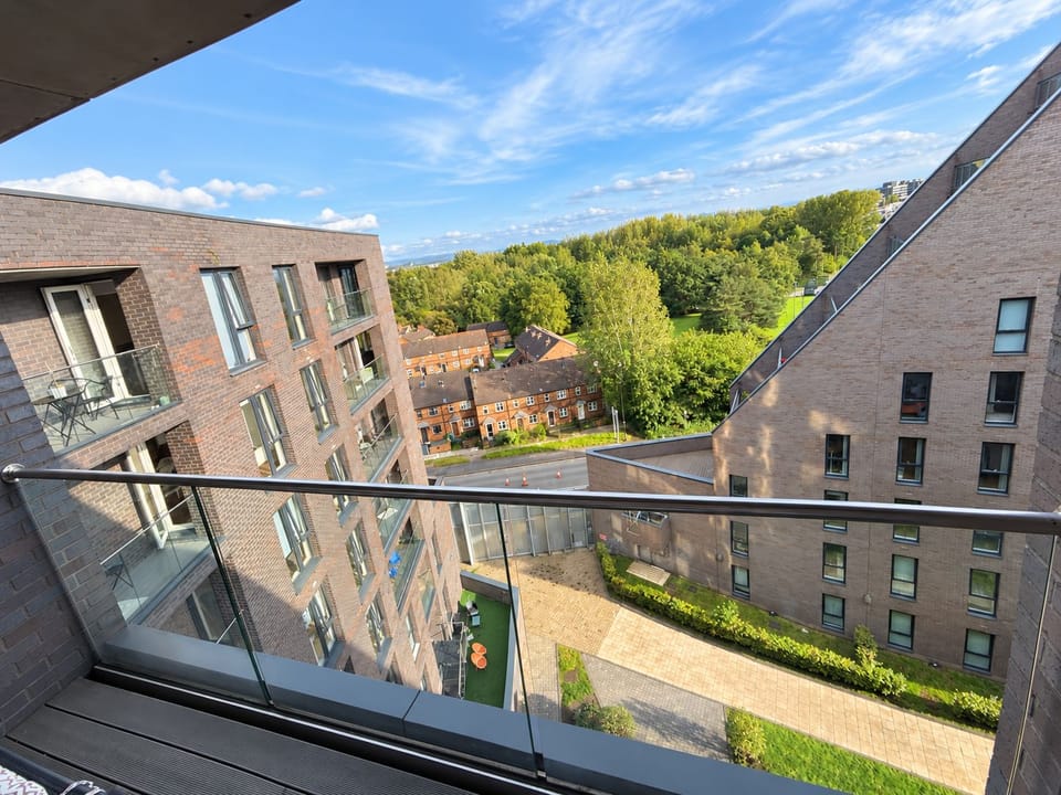 Private balcony with open views, natural light, and leafy surroundings