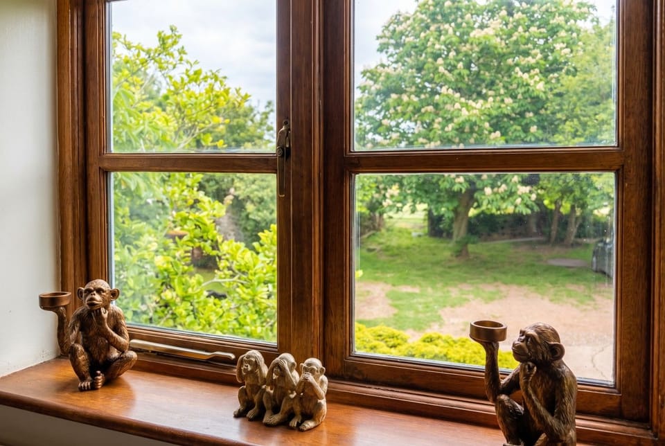 The bath takes a hand shower beside a window over the garden.