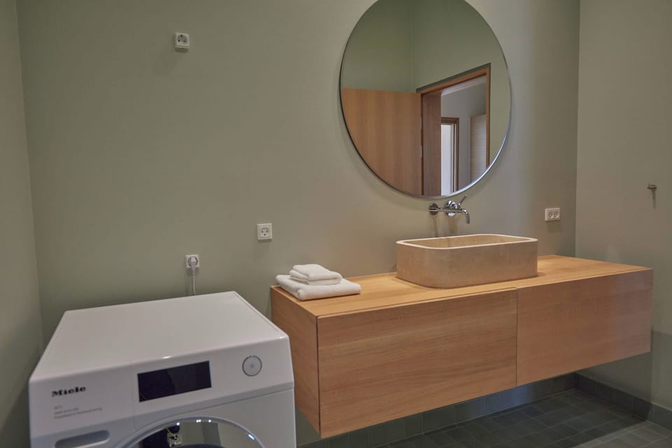 Bathroom 1 with toilet, 2 sinks and 
Miele washing and drying machine