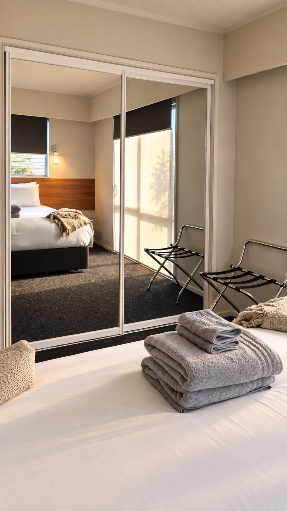 Bright modern bedroom with mirrored wardrobe and guest-ready touches