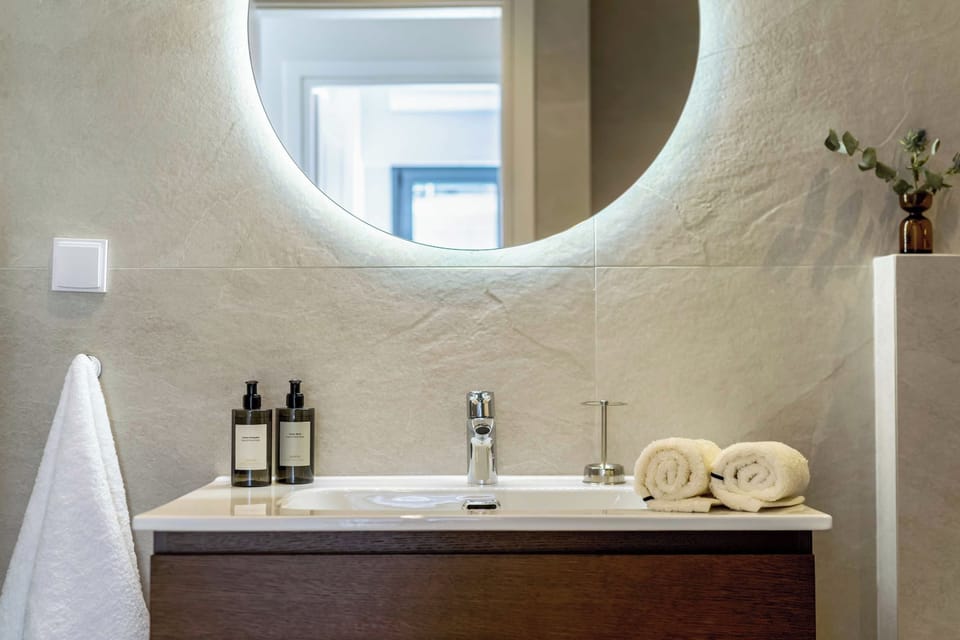 Bathroom vanity beneath the illuminated mirror