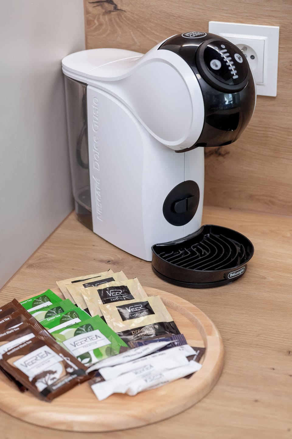 A compact coffee station with a coffee machine placed on a small countertop. Several coffee-related items and accessories are arranged neatly beside it.