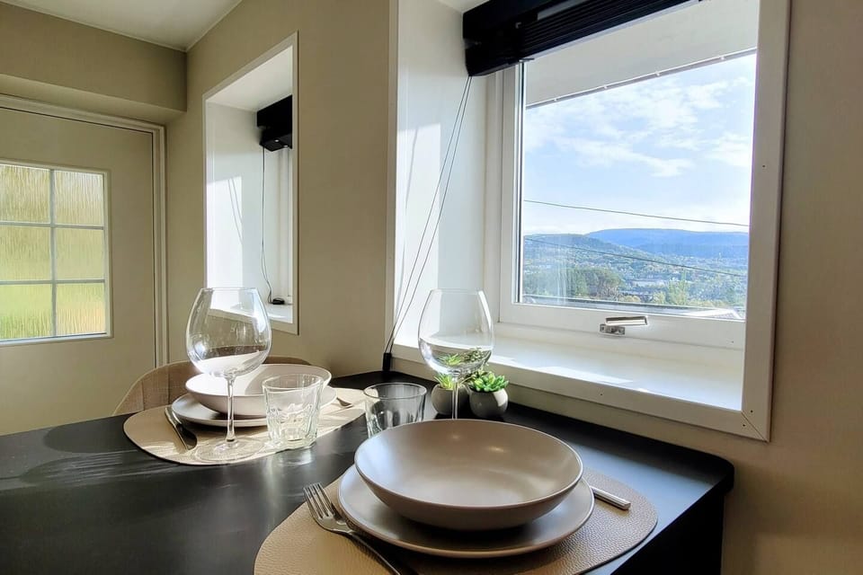 The dining table by the window, so you can eat with the view in front of you.