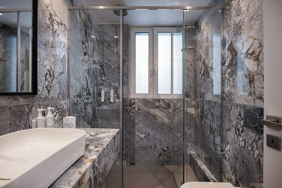 A sleek bathroom with walk-in shower and clean, contemporary finishes ensures a refreshing and comfortable stay experience.