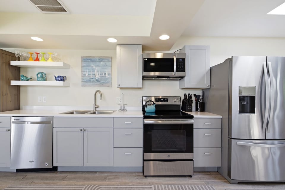 Modern kitchen with full-size stainless steel appliances, including a refrigerator, dishwasher, stove, and microwave.