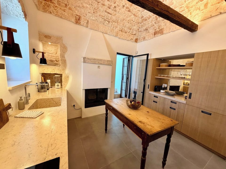 Kitchen with fireplace, farmhouse table and stone ceiling