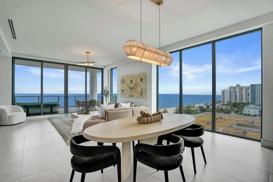 Dining area with a round table for six, statement artwork, and panoramic ocean views.
