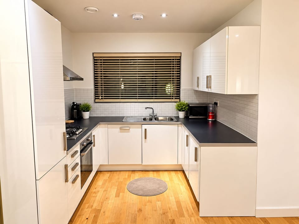 A fully equipped kitchen with an oven, fridge, stove, microwave, Nespresso machine, electric kettle, and bread toaster for your convenience.
