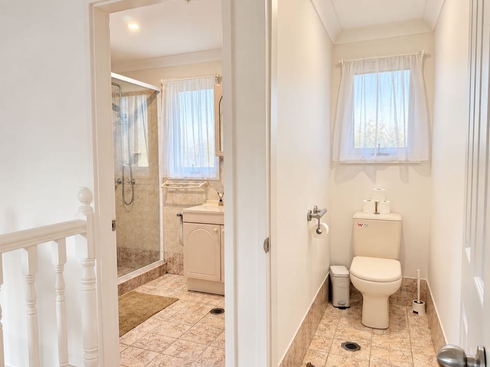Bright bathroom with separate toilet, shower, and natural light