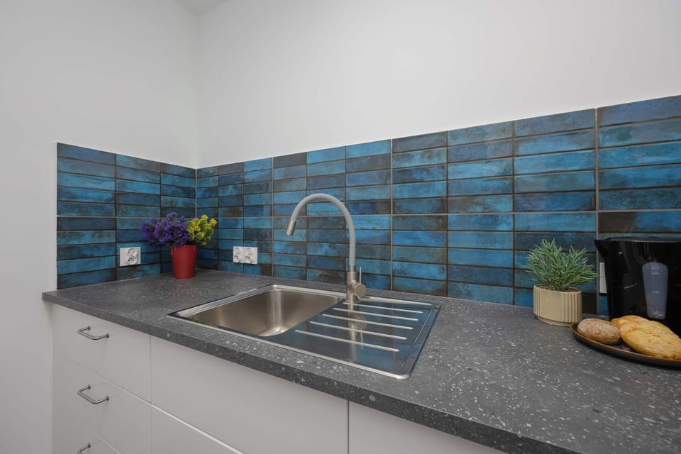 The kitchen's sleek design includes all necessary cookware and utensils. 