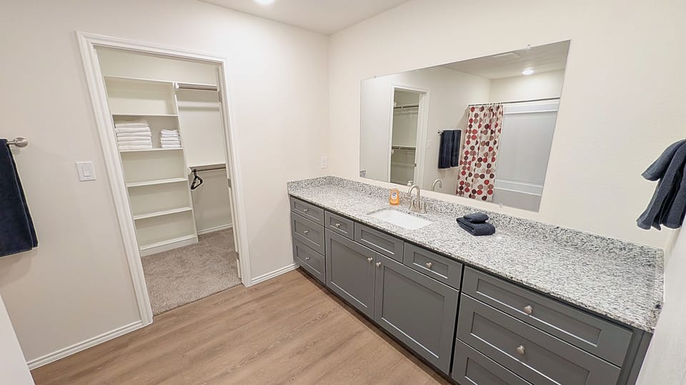 Spacious bath with granite double vanity and walk-in closet