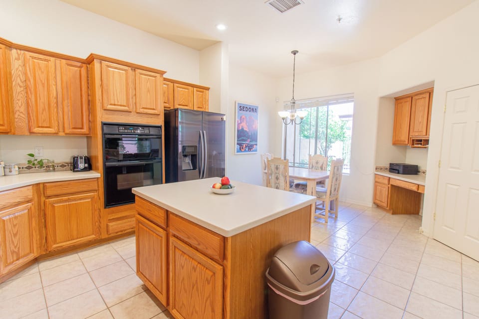 Spacious kitchen with large island, stainless appliances, dining nook, and dedicated workspace