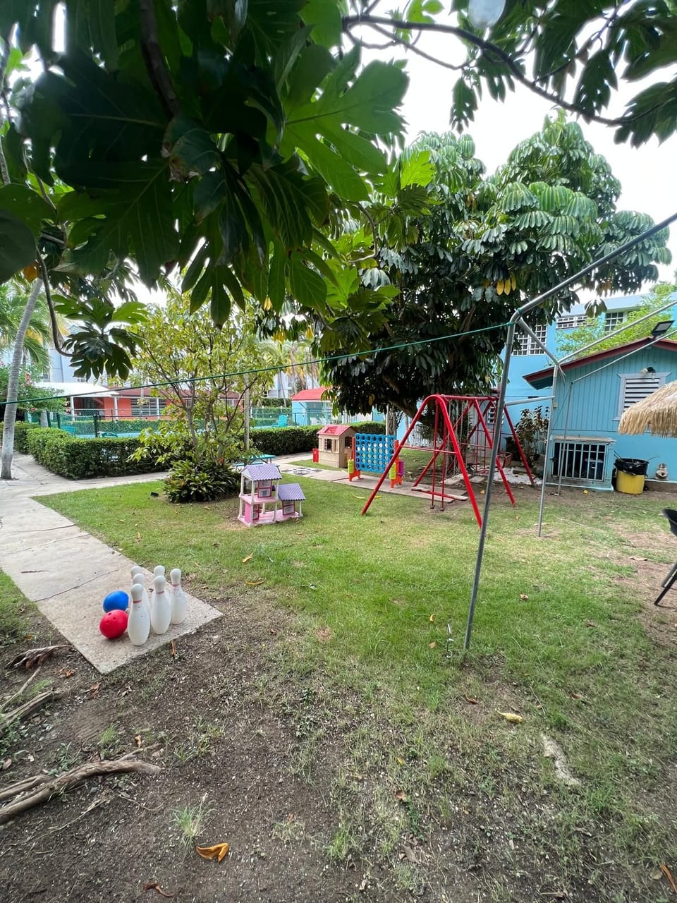 Outdoor playground with swings surrounded by lush greenery for the kids
