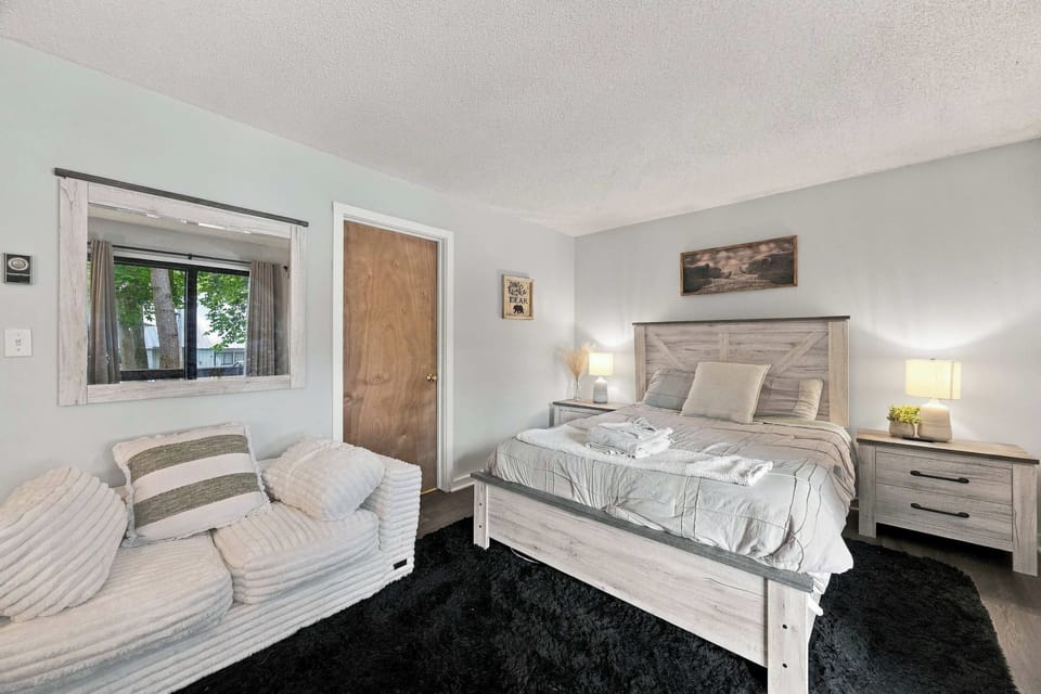 Bedroom with a plank-style headboard and lounge chair